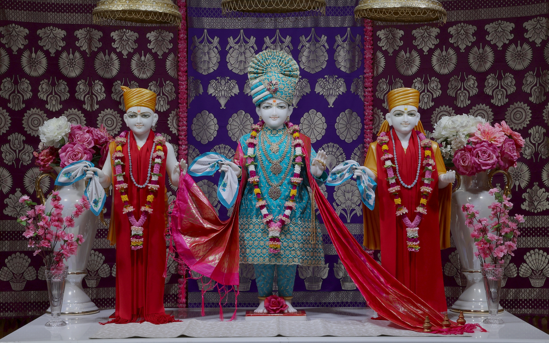 In Centre, Poorna Purushottam Shree Sahajanand Swami Maharaj, On Left Anadi Mul Akshar Murti Shree Gunatitanand Swami and On Right Anadi Mahamukta Shree Gopalanand Swami