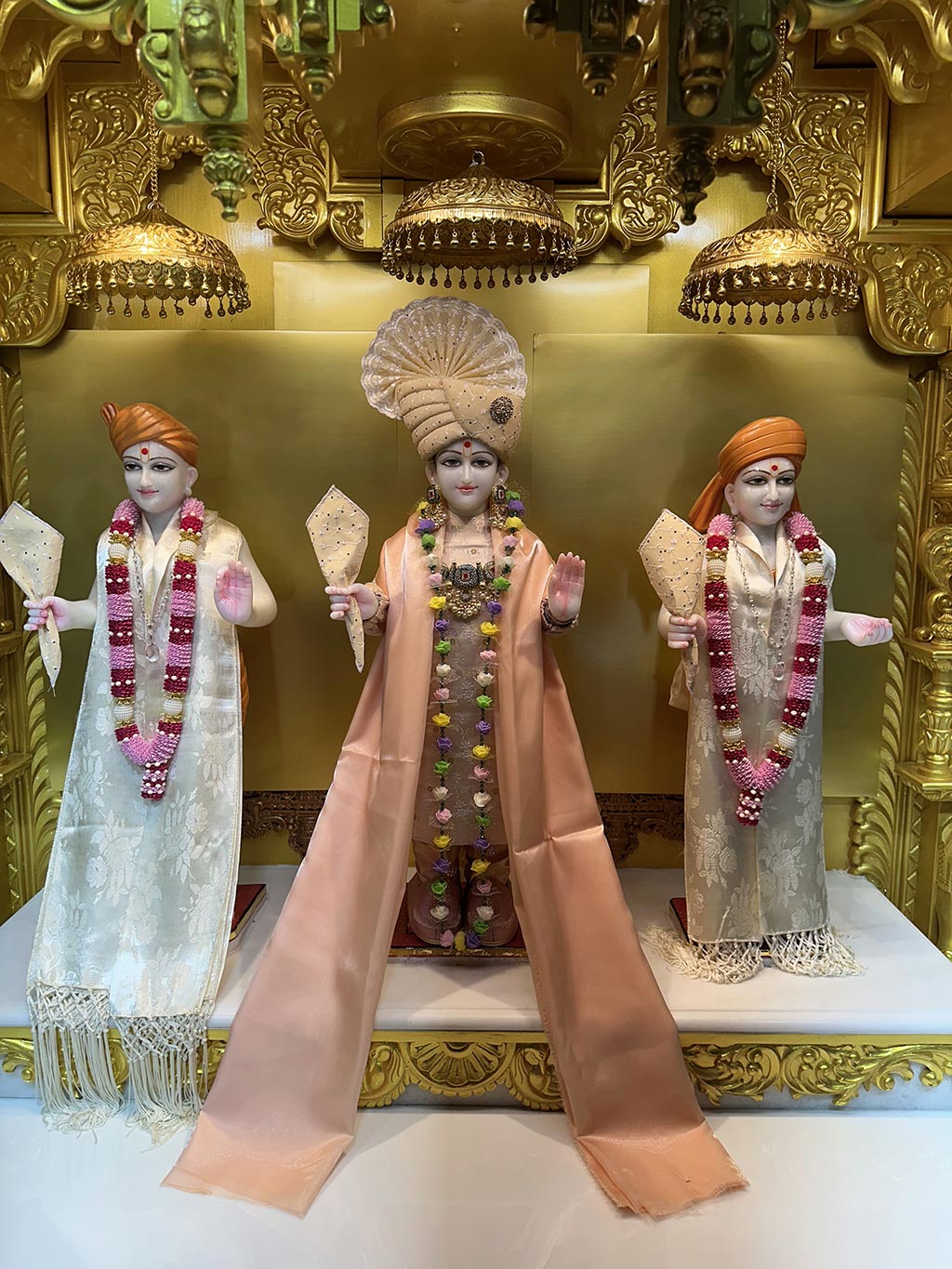 In Centre, Poorna Purushottam Shree Sahajanand Swami Maharaj, On Left Anadi Mul Akshar Murti Shree Gunatitanand Swami and On Right Anadi Mahamukta Shree Gopalanand Swami