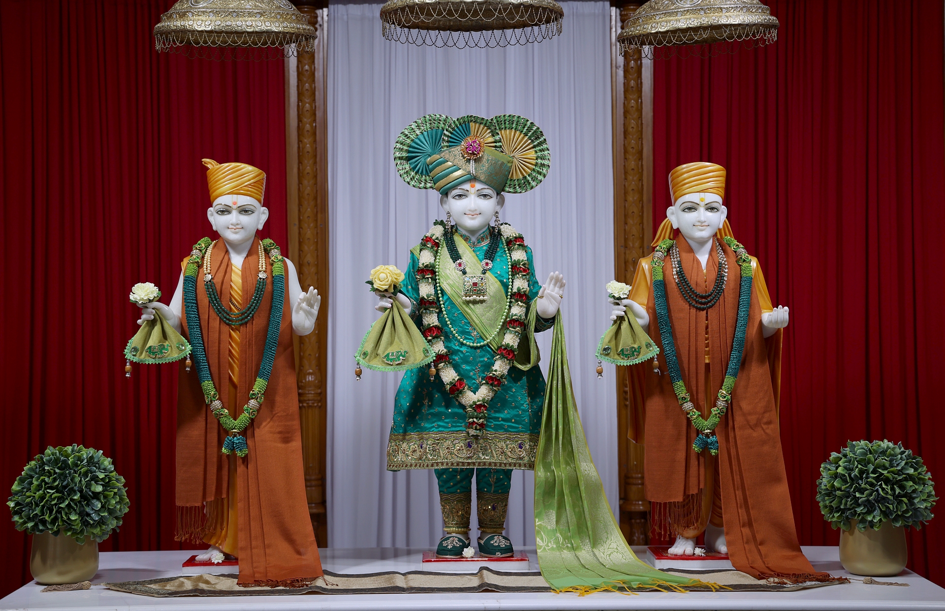 In Centre, Poorna Purushottam Shree Sahajanand Swami Maharaj, On Left Anadi Mul Akshar Murti Shree Gunatitanand Swami and On Right Anadi Mahamukta Shree Gopalanand Swami