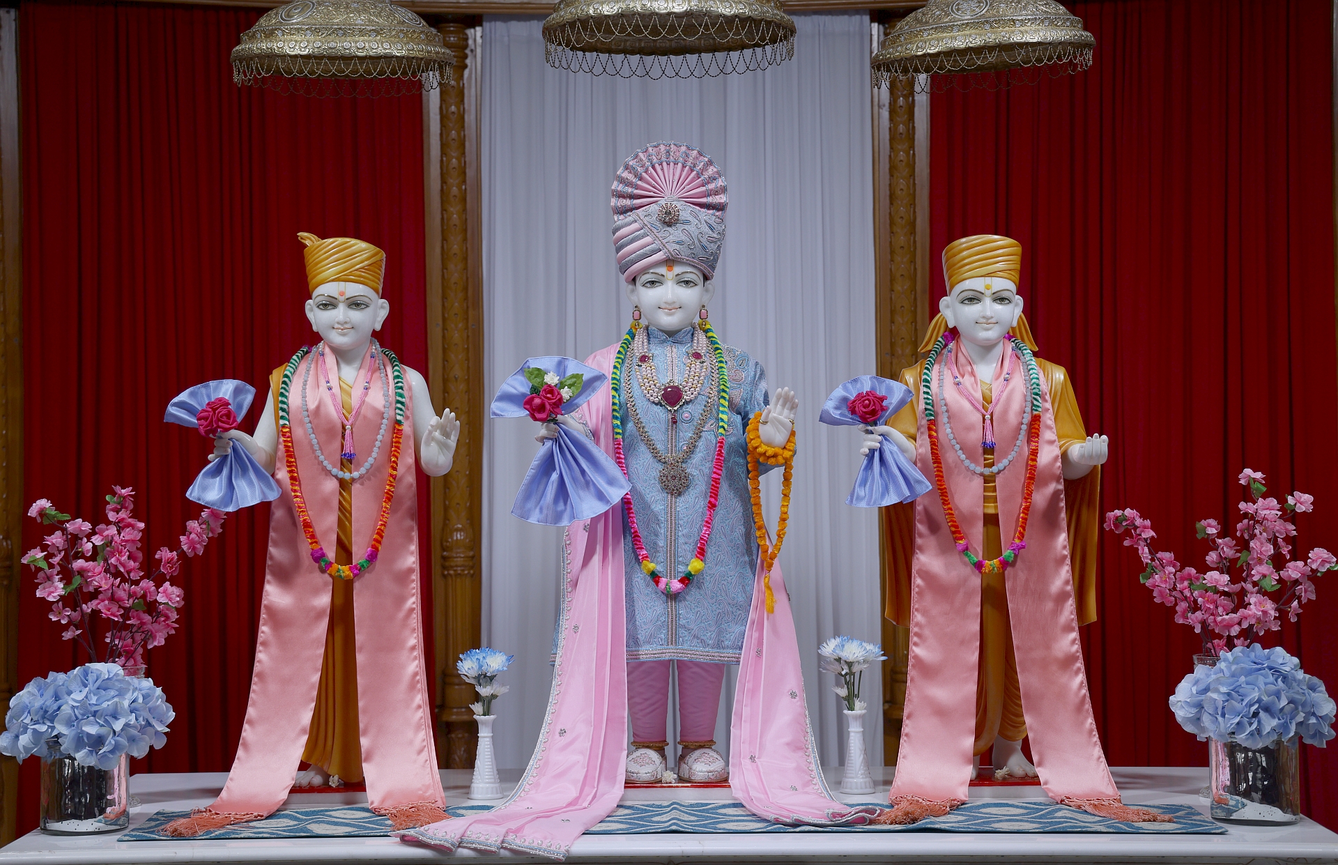 In Centre, Poorna Purushottam Shree Sahajanand Swami Maharaj, On Left Anadi Mul Akshar Murti Shree Gunatitanand Swami and On Right Anadi Mahamukta Shree Gopalanand Swami