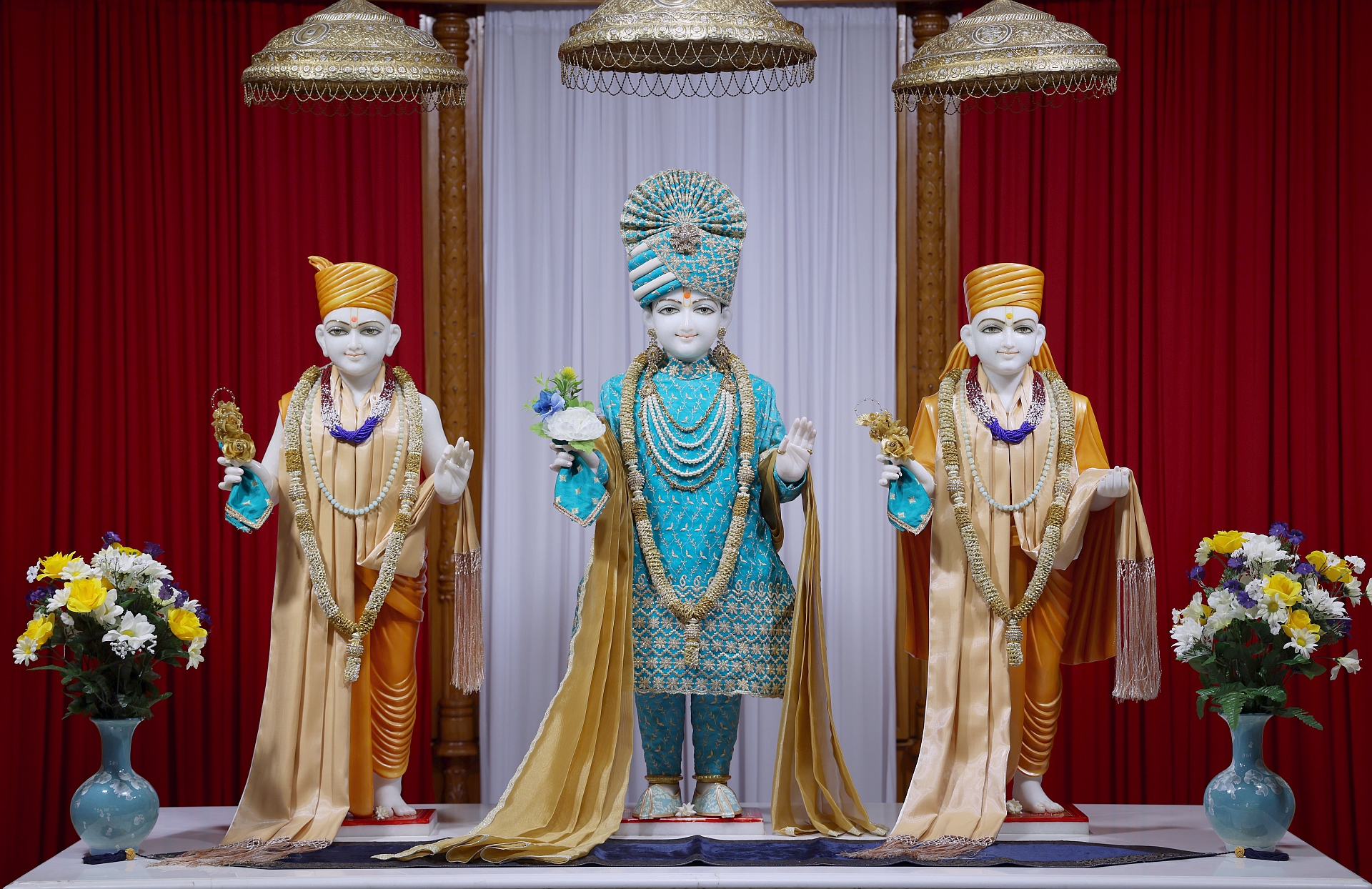 In Centre, Poorna Purushottam Shree Sahajanand Swami Maharaj, On Left Anadi Mul Akshar Murti Shree Gunatitanand Swami and On Right Anadi Mahamukta Shree Gopalanand Swami