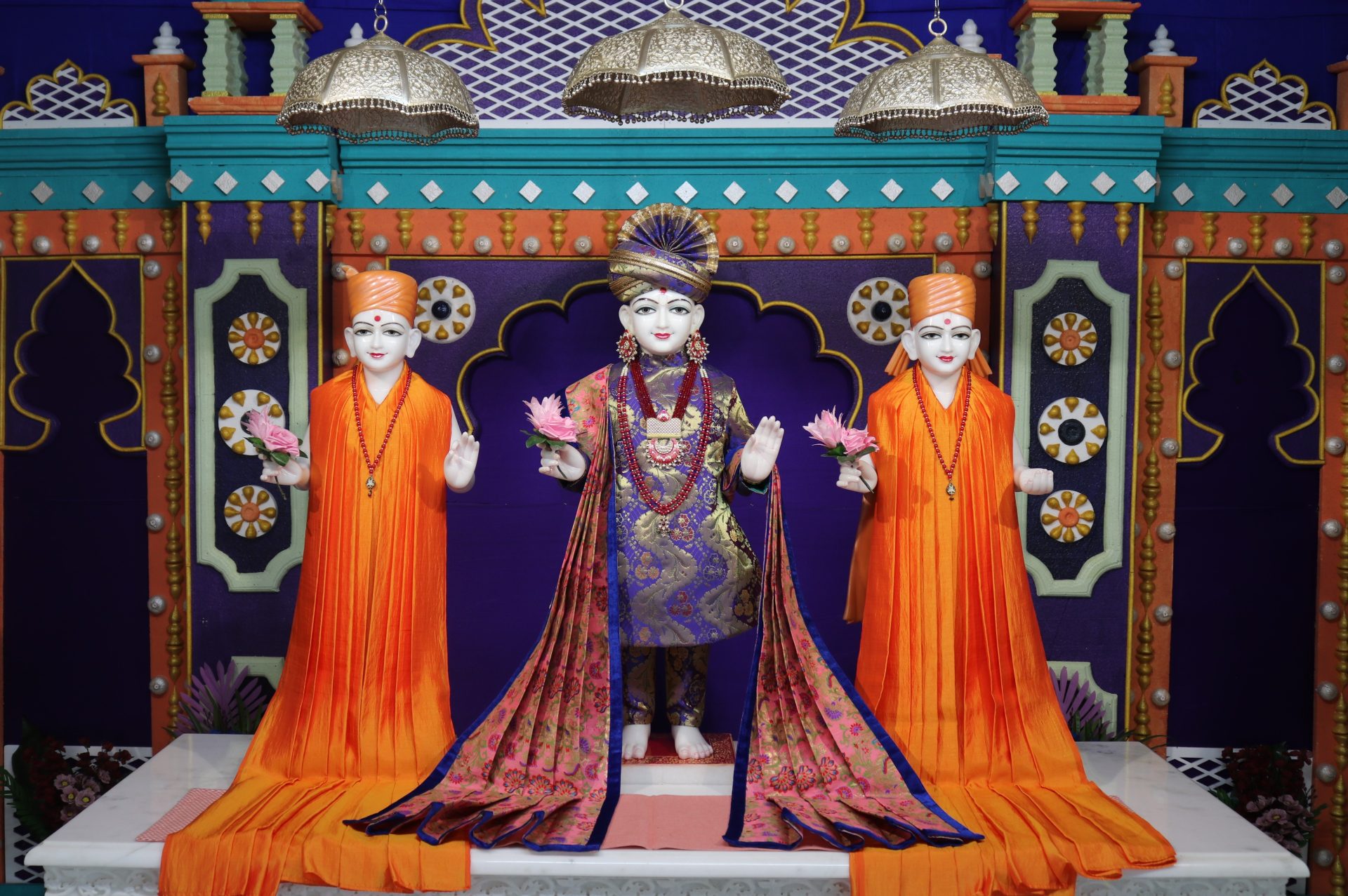 In Centre, Poorna Purushottam Shree Sahajanand Swami Maharaj, On Left Anadi Mul Akshar Murti Shree Gunatitanand Swami and On Right Anadi Mahamukta Shree Gopalanand Swami